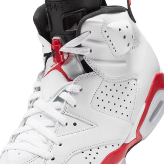 Men's white high-top sneakers close-up with red lace hardware and black lining