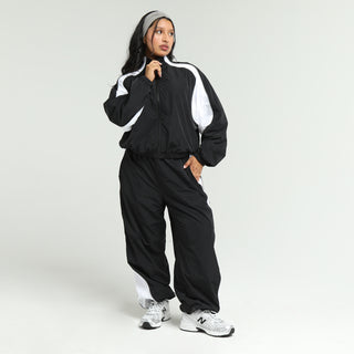 Women’s black wind pants with white side panels and elastic ankle cuffs