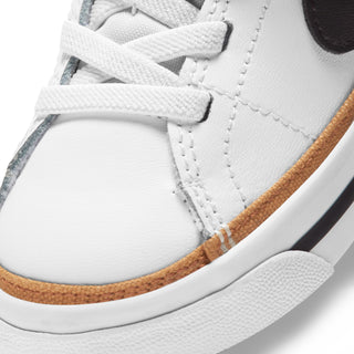 White toddler sneaker close-up with tan midsole trim and textured rubber outsole