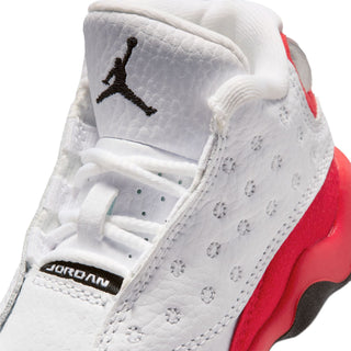 Toddler retro sneaker close-up: white leather upper with perforations, red trim, Jordan logo