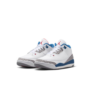 Kids white lace-up sneakers with blue side panels, red eyelets, and cement grey print.