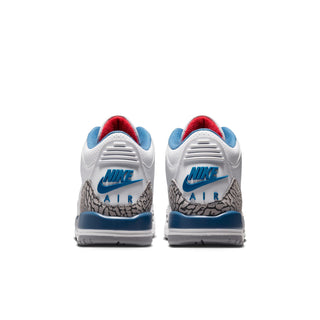 Youth white leather sneakers with Nike Air heel text, blue midsole, and elephant-print panels