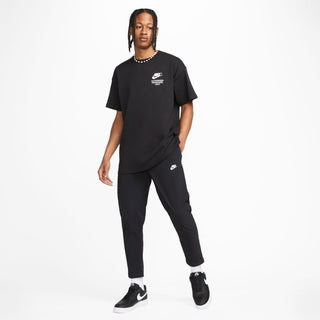 Black Nike t-shirt with logo and “Authorized Personnel Only” text, styled with black pants