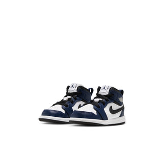 Pair of toddler mid-top sneakers in white and navy with black accents and swoosh