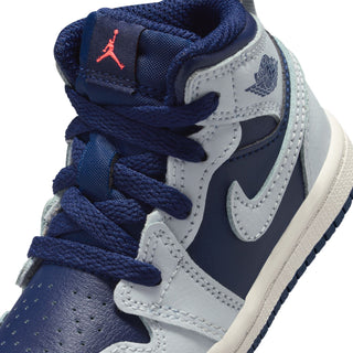 Toddler sneaker close-up: navy laces, white panels, swoosh logos, and red Jumpman mark