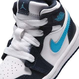 Toddler sneaker close-up, white panels with dark navy overlays and light blue Nike swoosh