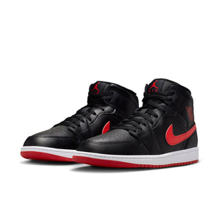 Black pair of mid-top sneakers with red Swoosh and white rubber sole