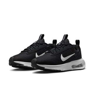 Pair of black Nike Air Max INTRLK Lite sneakers with white Swooshes and visible air cushioning