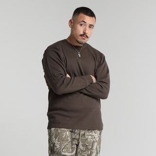 Mens dark brown long-sleeve thermal shirt worn with arms crossed; crew neck