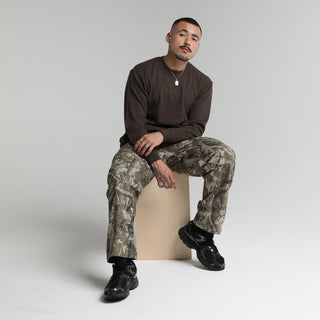 Dark brown long-sleeve thermal shirt with crew neck; seated model styling