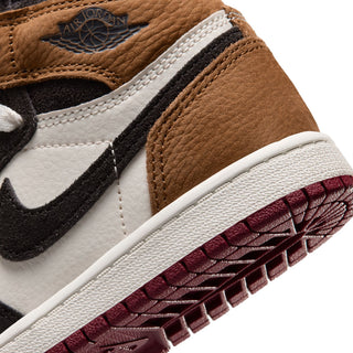 Close-up of kids high-top sneaker side panel with Jordan tag, brown leather and black swoosh