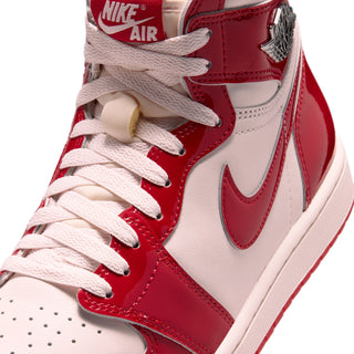 Close-up of high-top sneaker laces, red glossy panels, and white toe box