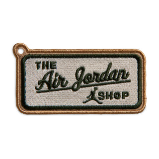 Clothing tag patch reading "The Jordan Shop" with stitched border