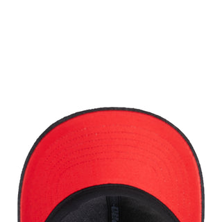 Red inner lining of a washed black strapback cap with black brim edge