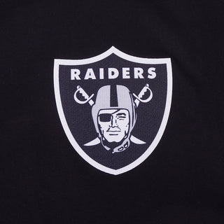 Close-up of white Raiders shield logo on black T-shirt chest