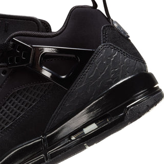 Close-up of youth black sneaker side with sculpted panel, strap buckle, and midsole unit