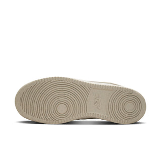 Cream sneaker outsole with circular tread pattern and embossed Nike logo