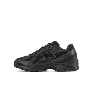 Youth black running shoes with large N logo, side view