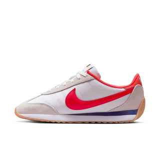 Women's low-top sneakers side view in white with red swoosh and blue stripe