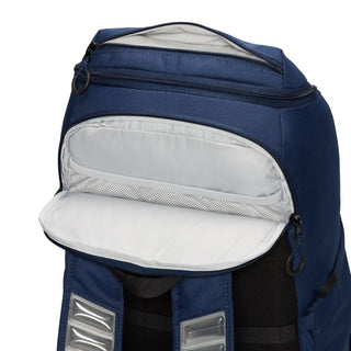 Navy backpack with open front pocket, white pouch lining, and two silver patch tabs