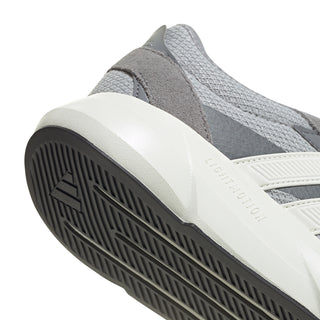 Grey sneaker side close-up with white midsole and black tread outsole
