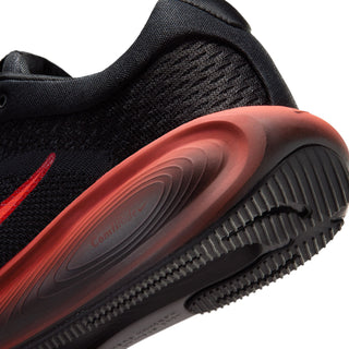 Close-up of black running shoe with sculpted red sole and textured outsole.