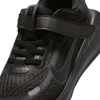 Close-up of black kids' Nike shoe showing mesh, laces, hook-and-loop strap and logo