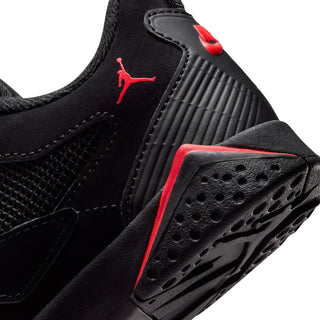 Kids' black sneaker close-up with red logo and grooved rubber outsole with holes