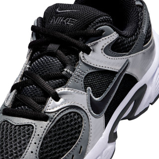 Nike youth sneaker upper close-up with black laces, silver overlays, and swoosh logo