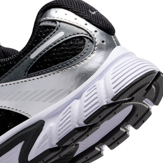 Nike youth shoe close-up of silver side panel and white sole with traction grooves