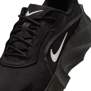 Close-up of black womens lace-up shoe with Nike swoosh and breathable upper texture