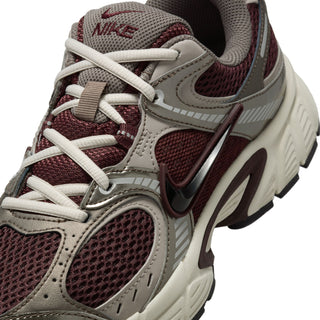 Women's running shoes close-up: burgundy mesh, gray overlays, white laces, swoosh logo