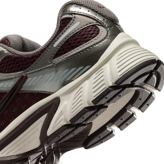 Women's running shoes close-up of side sole: burgundy upper, gray trim, textured tread