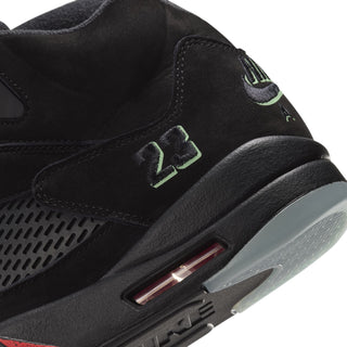 Black high-top sneaker close-up with heel air unit detail and green logo patch