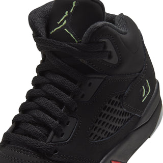 Black kids sneaker close-up of laces and side mesh, green logo and gray midsole trim