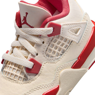 Toddler sneaker close-up: pale ivory leather, red trim, woven mesh panel, white laces