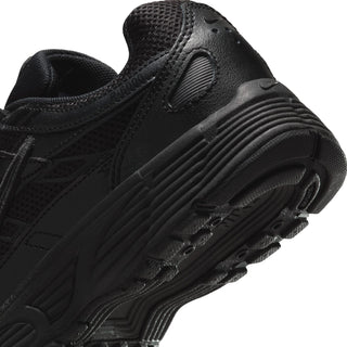 Youth running shoe side close-up in black with ribbed midsole and durable outsole.