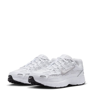 Youth white sneakers with double pair laces, mesh panels, and dark outsole tread
