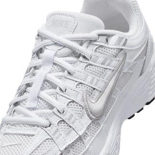 Close-up of youth white mesh sneaker: laces, stitching, and layered synthetic panels