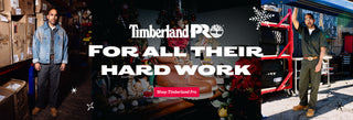 Two men standing in a workshop with Timberland Pro branding and text 'For all their hard work'.