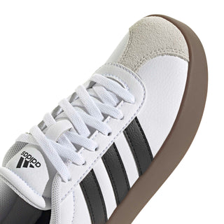 Youth adidas sneakers close-up, white laces and black stripes with textured collar