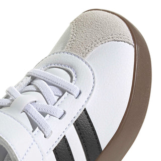 Kids white sneaker upper with black stripes, stitched details, and suede heel