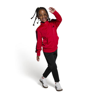 Kids shoes on a child: white sneakers with black stripes and gum soles