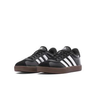 Youth black court sneaker with white triple stripes and gum-brown outsole