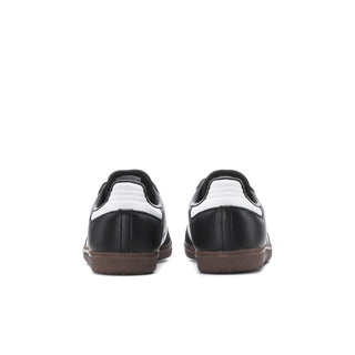 Youth black sneakers with white heel trim and gum rubber outsole, rear view.