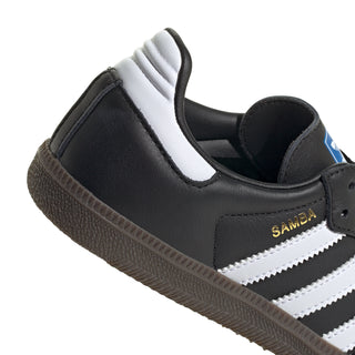 Youth black slip-on style sneakers with white stripes, cushioned collar, and gum sole.