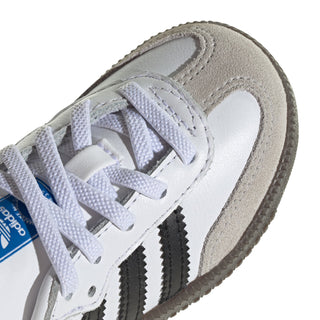 Toddler white sneaker toe with black stripes, lace-up front, textured gum sole