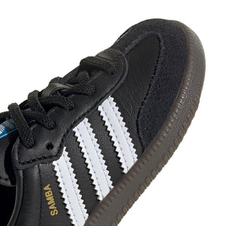 Close-up of toddler black sneaker upper with white stripes and textured gum outsole