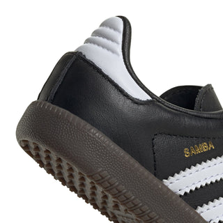 Close-up of toddler sneaker heel, black upper with “Samba” text and gum sole