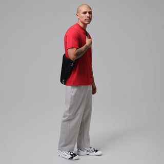 Men’s basketball shoes in white/black worn with gray pants and a red T-shirt